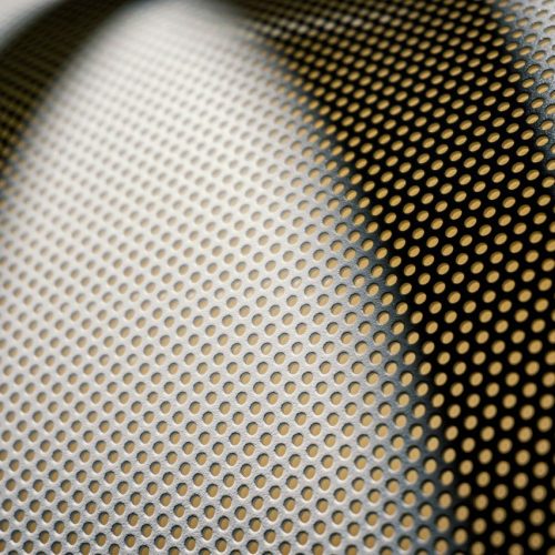 Detailed close-up of a textured, perforated metal surface showcasing pattern and design.